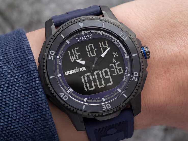 Reloj Timex Ironman Adrenaline ana-digi de color negro con correa azul oscuro y corona con detalles en azul, mostrado en una muñeca.