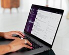 Manos escribiendo en un portátil con una aplicación de chat abierta