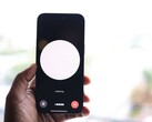 Una mano que sostiene un smartphone con una interfaz de asistente de voz en la pantalla