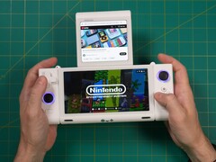 Russ de Retro Game Corps sosteniendo la consola de juegos portátil de doble pantalla OneXSugar Sugar 1, con un juego de Nintendo en la pantalla principal y un vídeo de YouTube reproduciéndose en la pantalla secundaria. (Fuente de la imagen: Retro Game Corps en YouTube)