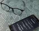 Un smartphone con la aplicación ChatGPT abierta junto a unas gafas sobre una superficie estampada
