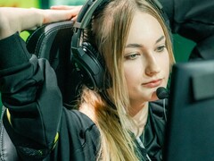 Un streamer con unos auriculares para videojuegos provistos de un micrófono de brazo, frente a una pantalla durante una retransmisión en directo