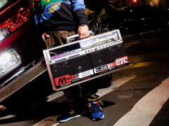 Una persona sostiene el Bumpboxx BB-777 junto a un coche.