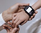 La mano de un adulto colocando un reloj inteligente en la muñeca de un niño