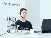 Un usuario de la tecnología de control mental de BrainCo que, de forma automática, coge una manzana con solo el poder de la mente.