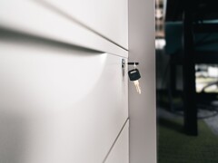 Una llave insertada en la cerradura de un cajón de madera cerrado