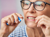 Imagen de una mujer utilizando hilo dental. El hilo dental podría convertirse en un nuevo medio de vacunación (Fuente de la imagen: imagen generada por IA)