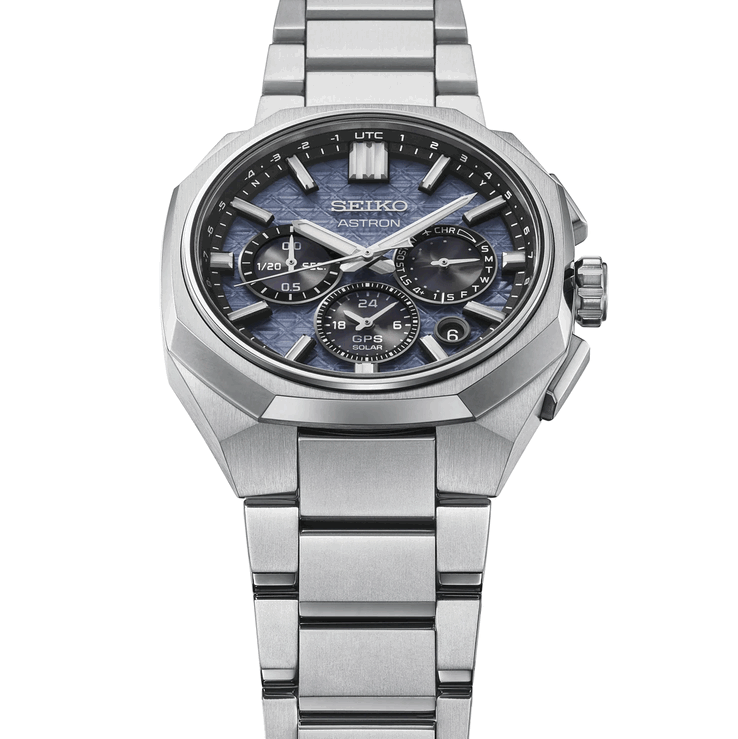 Vista frontal en ángulo del Seiko Astron HAB001 que muestra su bisel de titanio facetado, el brazalete integrado y la esfera azul texturizada.