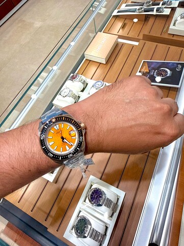 Reloj de buceo Seiko Prospex HBB005K1, inspirado en el tigre, lucido en la muñeca, en el que se aprecia su esfera de textura ámbar, su bisel negro con detalles en naranja y su caja y brazalete de acero inoxidable.