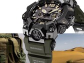 Primer plano del Casio G-Shock Mudmaster GWG-B1000-1A3, en el que se aprecian su caja negra, los detalles en color beige de la esfera, la correa verde oliva, los resistentes protectores y la inscripción «Triple Sensor», con un equipo militar y un paisaje desértico como fondo.