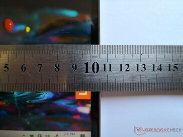 Unos 11 mm desde el borde de la pantalla hasta el borde de la tapa