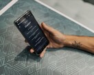 Mano sosteniendo un smartphone con la aplicación ChatGPT abierta sobre una mesa estampada