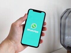Mano sosteniendo un smartphone con la aplicación WhatsApp abierta