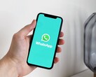 Mano sosteniendo un smartphone con la aplicación WhatsApp abierta