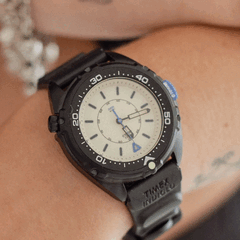 El Timex Intrepid x Dimepiece Blackout Edition presenta una caja de acero inoxidable negro, una esfera de color crema y detalles en morado