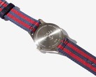 Vista trasera del reloj Noah x Timex MK1 Anchor, en la que se aprecia el fondo de la caja de acero inoxidable grabado y la correa de tela en azul marino y rojo.