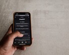 Mano sosteniendo un smartphone que muestra la interfaz de ChatGPT sobre una superficie de piedra gris