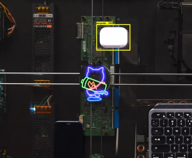 El cargador de escritorio AirPower de HTX Studio carga los AirPods mientras el gato animado sigue la bobina de carga.
