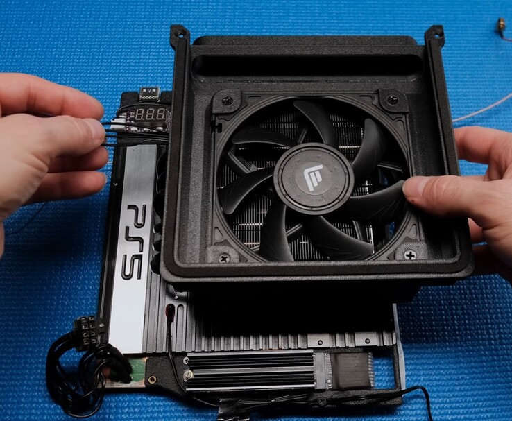 Primer plano de la configuración de refrigeración de la Tiny PS5 Redux con un ventilador Noctua, una cubierta impresa en 3D y la placa base PS5 expuesta. (Fuente de la imagen: Not From Concentrate vía YouTube)