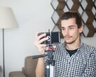 Un joven se graba a sí mismo en casa con un smartphone montado en un trípode