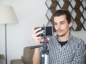 Un joven se graba a sí mismo en casa con un smartphone montado en un trípode