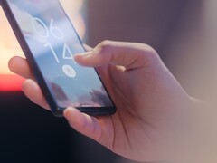 Una mano sostiene un smartphone y lo desbloquea mediante el sensor de huellas dactilares de la pantalla de bloqueo.