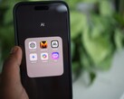 Mano sosteniendo un smartphone con una carpeta llena de aplicaciones de IA en la pantalla