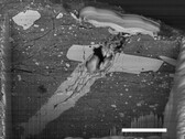 Imagen de microscopio electrónico de barrido de un cráter de impacto de micrometeorito en una partícula de material del asteroide Bennu (Fuente de la imagen: NASA, y Zia Rahman)
