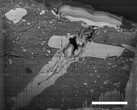 Imagen de microscopio electrónico de barrido de un cráter de impacto de micrometeorito en una partícula de material del asteroide Bennu (Fuente de la imagen: NASA, y Zia Rahman)