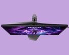 La imagen muestra el monitor para videojuegos AOC AG276UZ sobre un fondo morado. El monitor para videojuegos presenta un diseño muy orientado a los videojuegos, con iluminación RGB en la parte trasera.