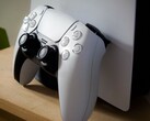 Una imagen de un mando DualSense de PlayStation 5 apoyado en una consola PS5