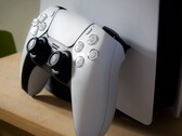 Una imagen de un mando DualSense de PlayStation 5 apoyado en una consola PS5