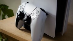Una imagen de un mando DualSense de PlayStation 5 apoyado en una consola PS5
