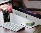 Un iMac sobre un escritorio con el dock de macOS visible en la pantalla y un teclado de Apple delante