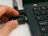 Una persona inserta una llave de seguridad USB en un ordenador portátil