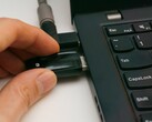 Una persona inserta una llave de seguridad USB en un ordenador portátil
