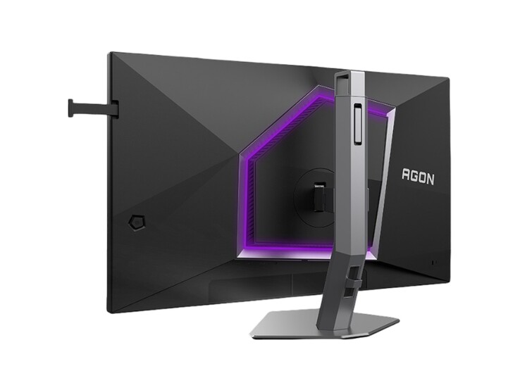 La imagen muestra la parte trasera del monitor para videojuegos AOC Agon Pro AG276UZ, que presenta un diseño bastante propio de los videojuegos con iluminación RGB morada.