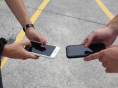 Dos personas sosteniendo dos teléfonos inteligentes uno al lado del otro durante una entrega