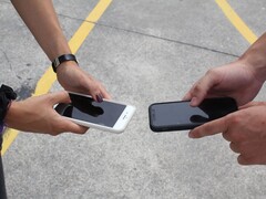 Dos personas sosteniendo dos teléfonos inteligentes uno al lado del otro durante una entrega