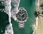 Reloj de buceo Seiko Prospex HBC001 con esfera y bisel verdes sobre un fondo aéreo de playa y océano.