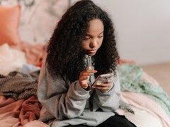 Adolescente usando un smartphone en una cama, imagen simbólica de ChatGPT for Teens y los controles parentales