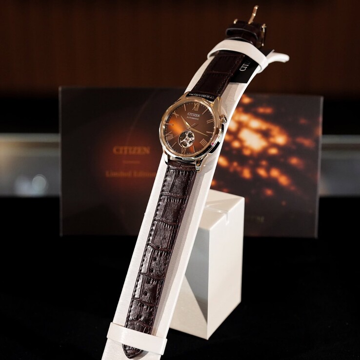 El reloj Citizen colocado sobre un expositor blanco y curvo. La imagen muestra la correa de piel marrón oscuro con relieve de cocodrilo en toda su longitud y la esfera marrón reflectante,