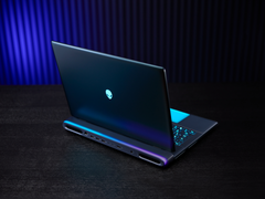 El portátil para juegos Alienware 18 Area-51, fotografiado sobre una mesa con un fondo poco iluminado. (Fuente de la imagen: Dell)