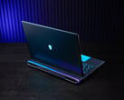 El portátil para juegos Alienware 18 Area-51, fotografiado sobre una mesa con un fondo poco iluminado. (Fuente de la imagen: Dell)