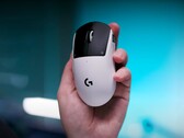 Ratón para juegos Logitech G Pro X2 Superstrike en una mano sobre fondo azul