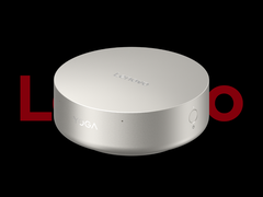 El mini PC Lenovo Yoga Mini i, fotografiado sobre un fondo negro con el logotipo de Lenovo en la parte superior. (Fuente de la imagen: Lenovo - editado)