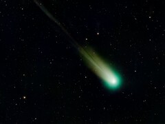 Una imagen que muestra un cometa con una cola verde.