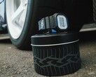 Reloj Casio G-Shock DW5600TT25-1 x Toyo Tires expuesto en una lata metálica con temática de neumáticos junto a una rueda de coche.