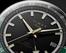 Primer plano de la esfera negra del Timex Atelier GMT Première M1a, con manecillas en tono dorado, índices horarios luminiscentes, ventana de fecha y anillo GMT de 24 horas en negro y verde.