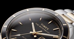 Primer plano del Timex Waterbury Heritage Automatic con esfera negra, en el que se aprecian sus agujas facetadas y luminiscentes, los índices horarios, el indicador de día y fecha y el bisel negro.